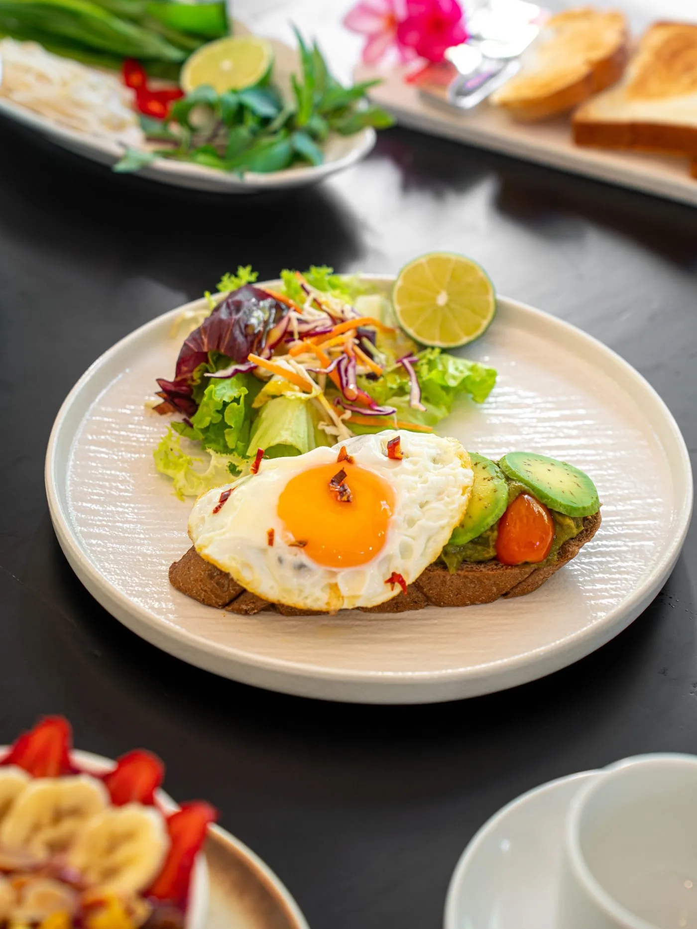 Healthy breakfast at Faifo: avocado and egg on toast with leaves and fresh fruit