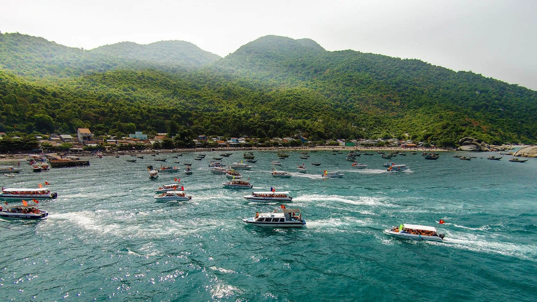 The bay of Cham Island, with boats anchored under the green hills