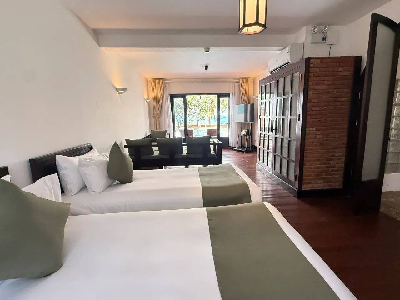Planta baja de una Private Pool Sea View Villa: dos camas, zona de estar y, al fondo, la cristalera a la piscina y al mar