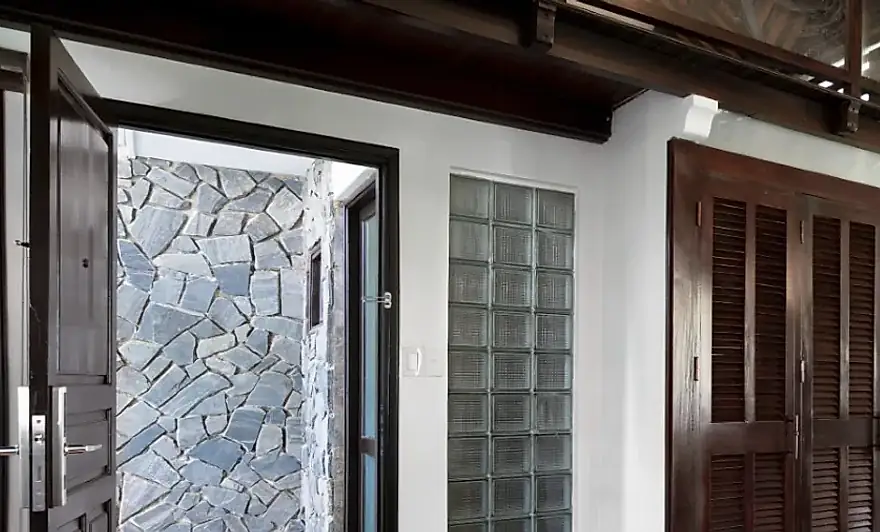 La puerta abierta al patio de piedra propio, con su muro de laja