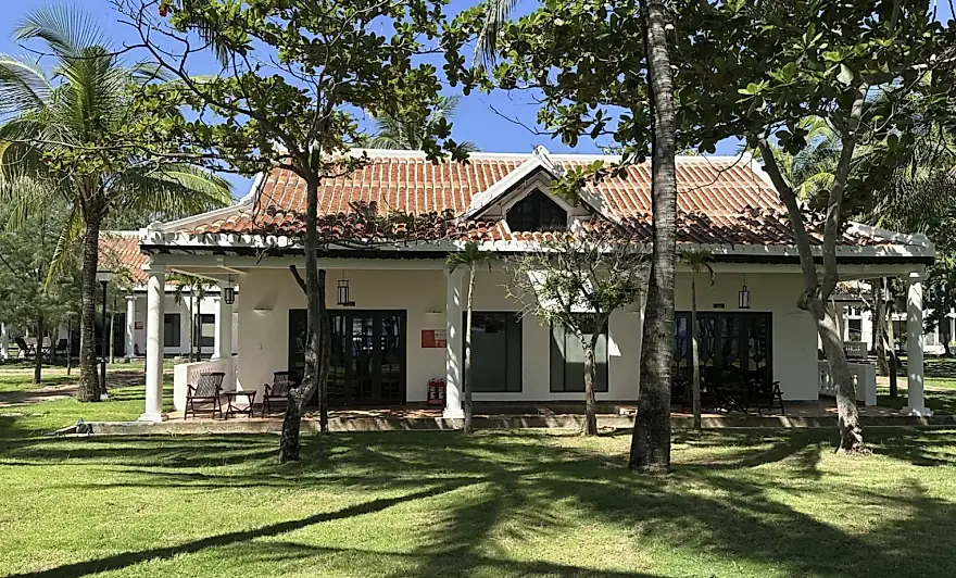 La Ocean Villa desde el césped: una sola planta bajo tejado de teja, entre los árboles